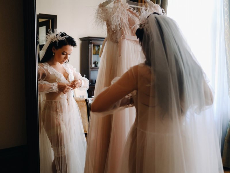 the bride, dressed in a boudoir transparent dress and underwear, stands at home in the morning by